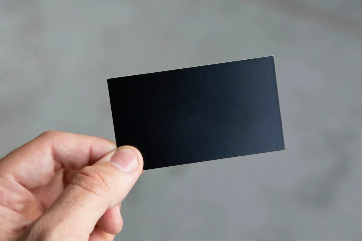 Hand holding a dark business card